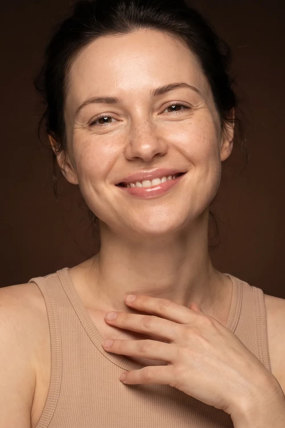 Femme souriante, la main sur la clavicule